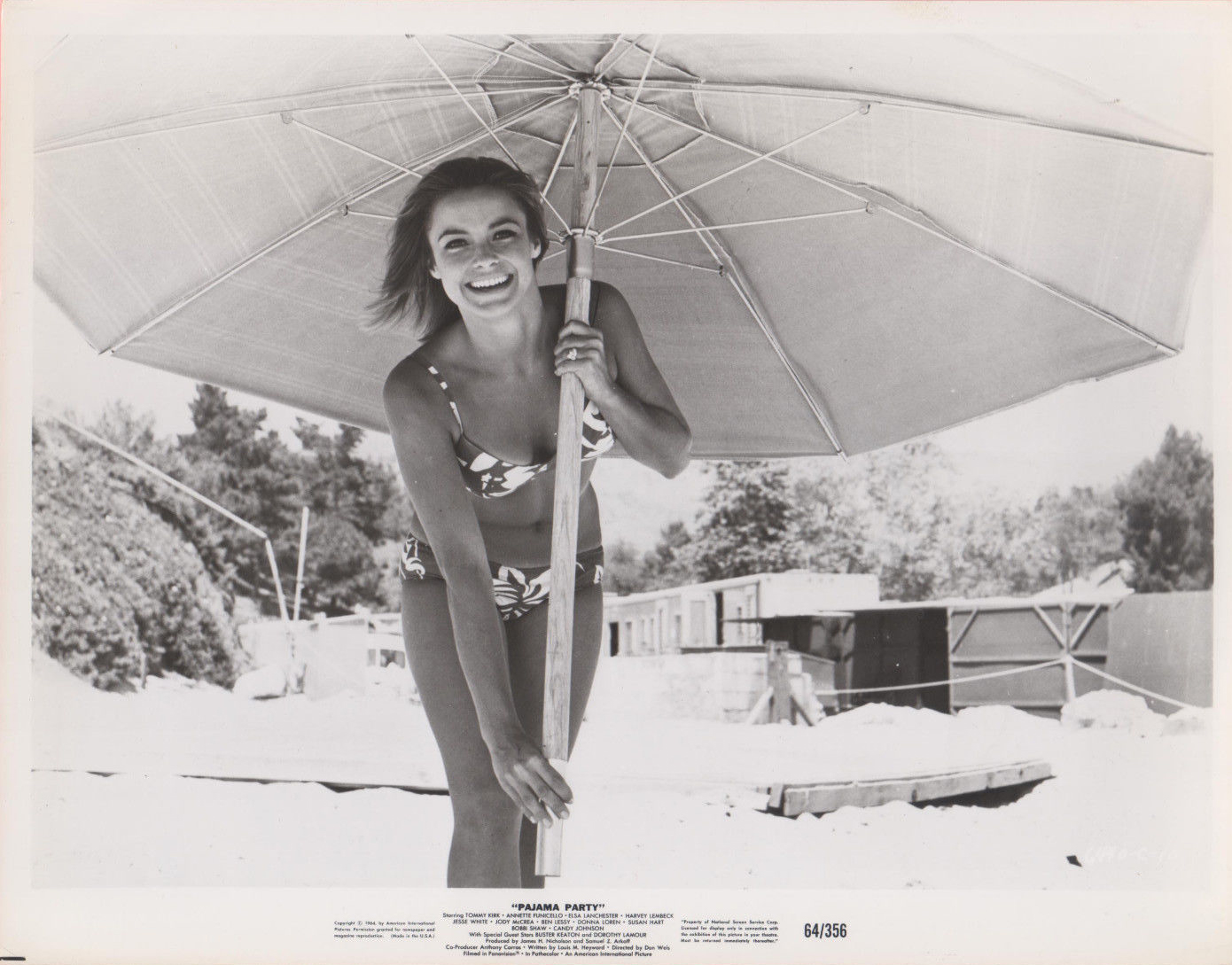 Patti Chandler in a bikini under an umbrella.